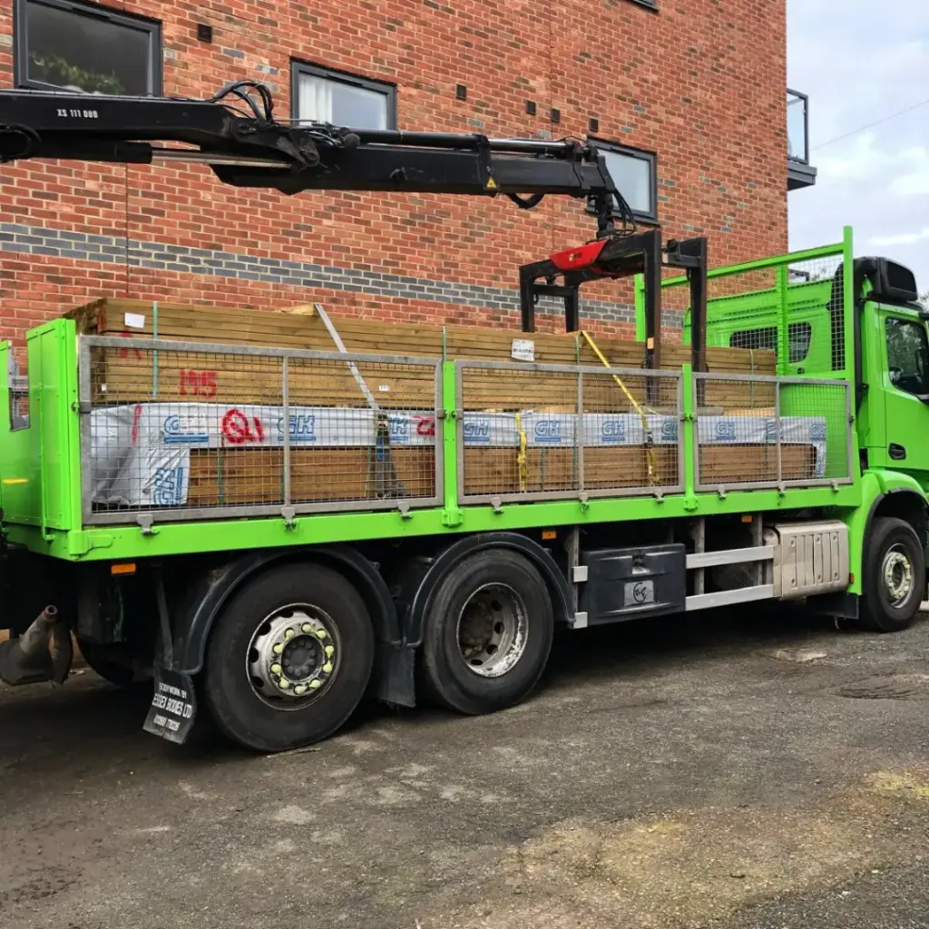 A Builders Megastore crane-equipped delivery lorry loaded with timber